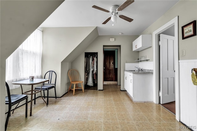 kitchen with white cabinetry, ceiling fan, and sink