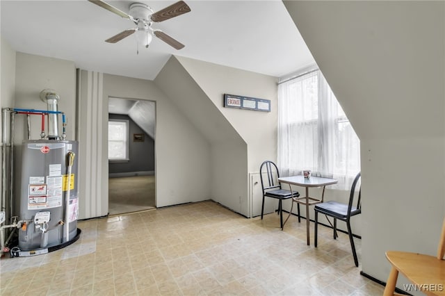 additional living space with lofted ceiling, water heater, and ceiling fan