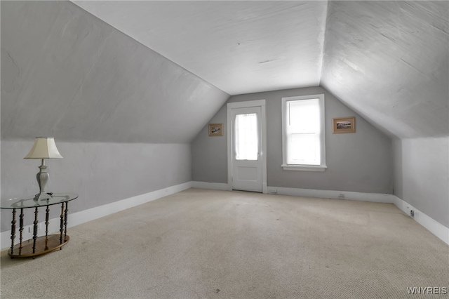 additional living space with lofted ceiling and light colored carpet