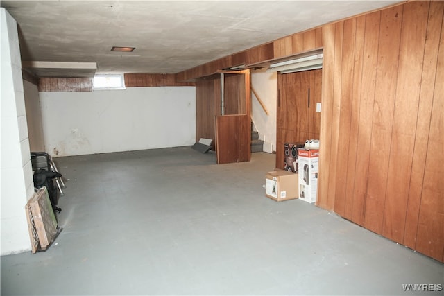 basement featuring wooden walls