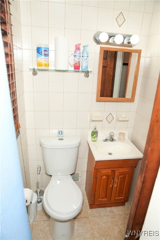 bathroom featuring tile walls, vanity, toilet, and tile patterned flooring