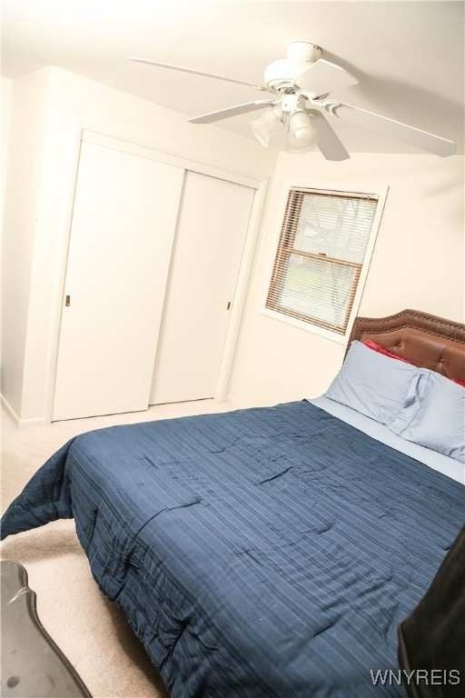 carpeted bedroom featuring a closet and ceiling fan