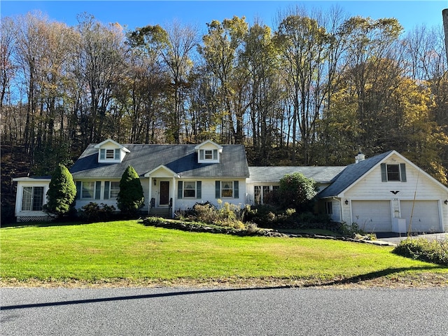 new england style home with a garage and a front yard