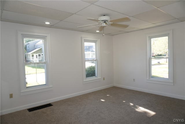 empty room with a drop ceiling, carpet flooring, and ceiling fan