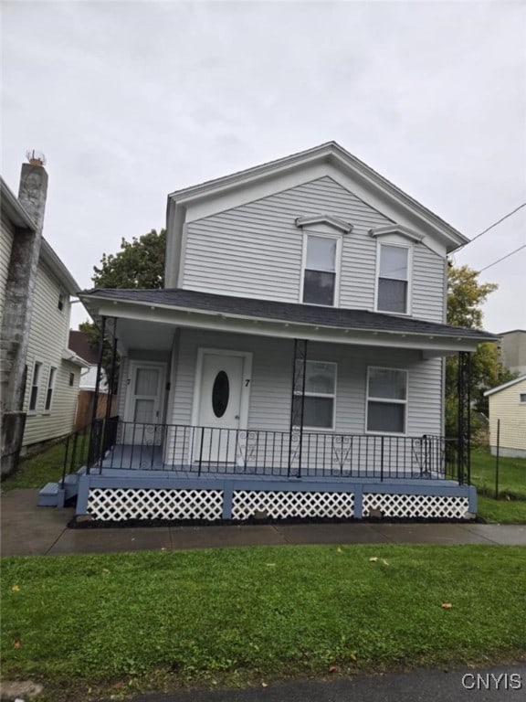 view of front facade with covered porch and a front yard