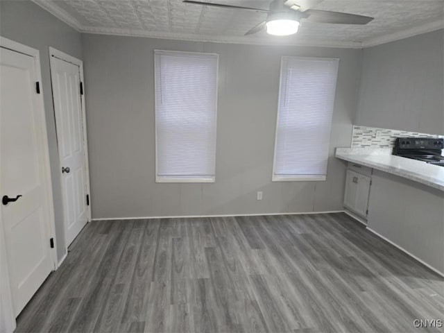 interior space featuring ceiling fan, a textured ceiling, black range with electric stovetop, and hardwood / wood-style floors