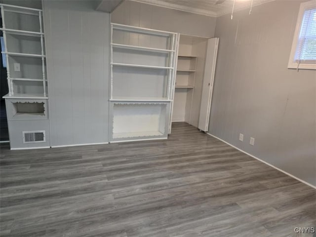 unfurnished bedroom with dark wood-type flooring and crown molding