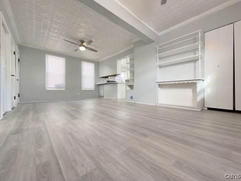 unfurnished living room with light wood-type flooring and ceiling fan