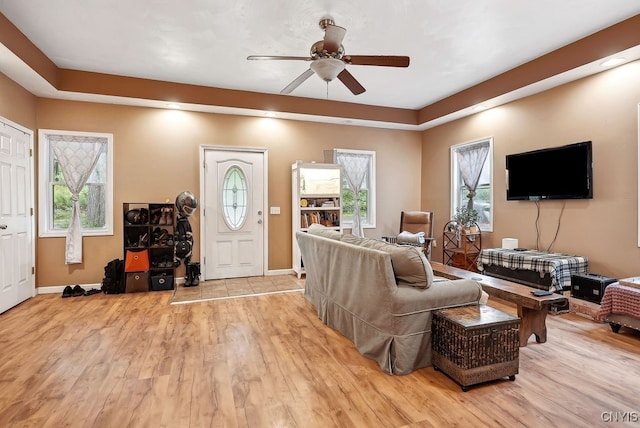 living room with light hardwood / wood-style flooring and ceiling fan