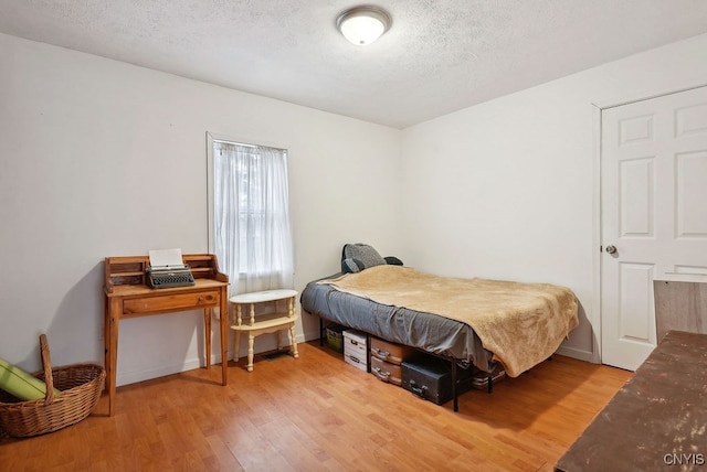 bedroom featuring hardwood / wood-style floors and a textured ceiling