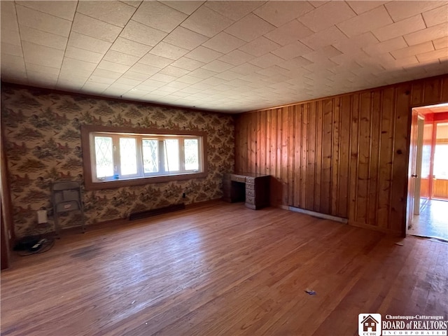 empty room with hardwood / wood-style floors and wooden walls