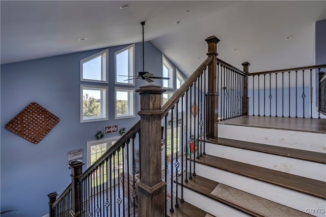 staircase with ceiling fan and high vaulted ceiling