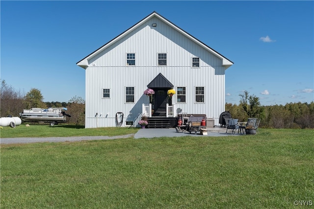 rear view of property featuring a patio and a lawn