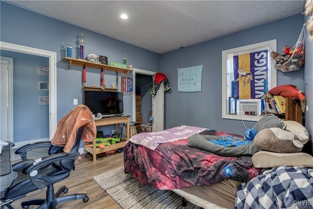 bedroom with cooling unit and wood-type flooring