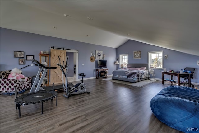 bedroom featuring vaulted ceiling, a barn door, and hardwood / wood-style floors