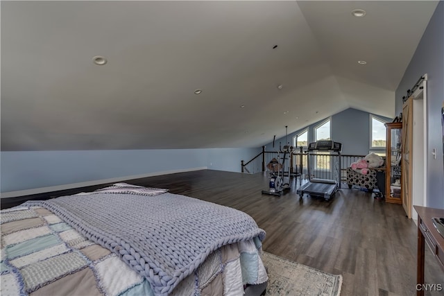 bedroom with lofted ceiling, dark wood-type flooring, and a barn door