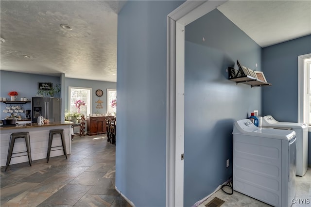 laundry room with washing machine and dryer and a textured ceiling