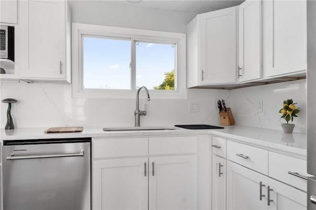 kitchen featuring sink, dishwasher, backsplash, a textured ceiling, and white cabinets