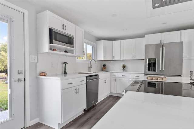 kitchen with white cabinets, stainless steel appliances, sink, and dark hardwood / wood-style floors