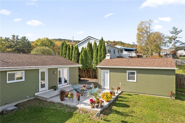 rear view of property featuring a patio area, french doors, and a yard