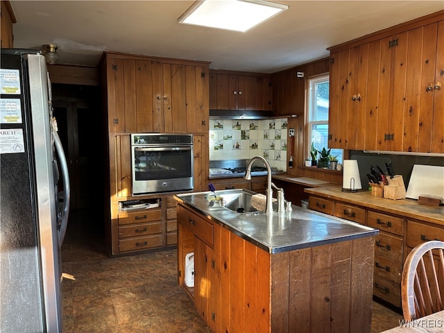 kitchen featuring stainless steel counters, oven, sink, tasteful backsplash, and refrigerator