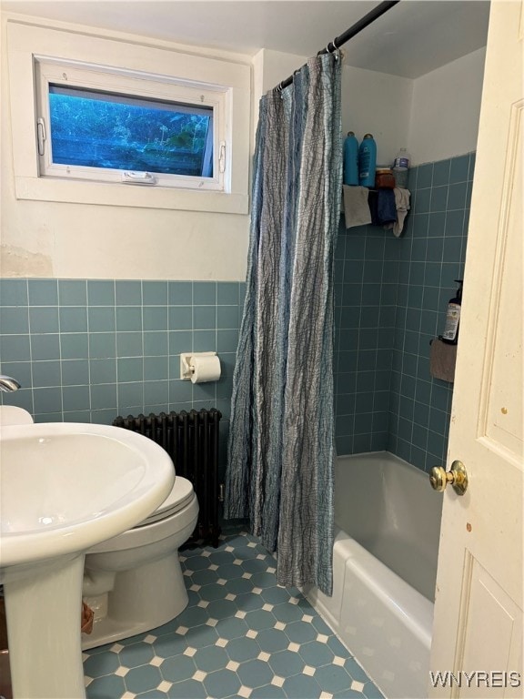 bathroom featuring toilet, tile walls, radiator heating unit, and shower / tub combo