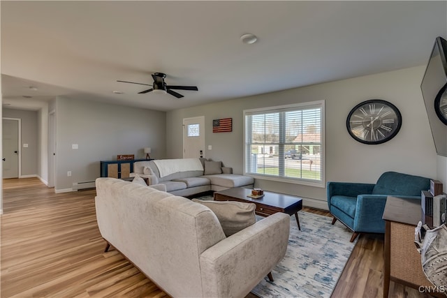 living room with ceiling fan, light hardwood / wood-style flooring, and baseboard heating