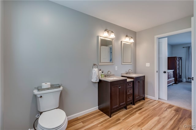 bathroom featuring toilet, hardwood / wood-style floors, and vanity