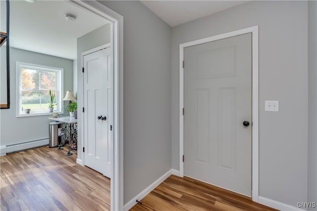 foyer entrance with light hardwood / wood-style flooring and a baseboard radiator