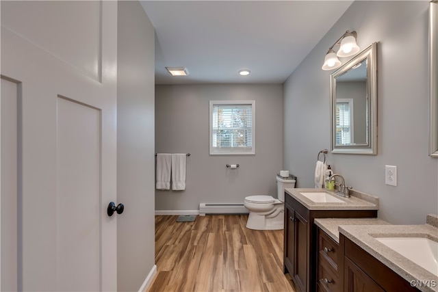 bathroom with vanity, a baseboard radiator, hardwood / wood-style flooring, and toilet