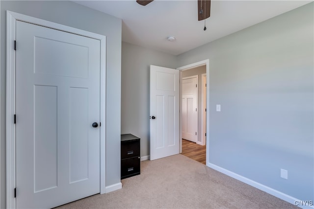 unfurnished bedroom featuring light colored carpet and ceiling fan