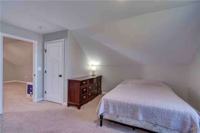 bedroom featuring lofted ceiling and light colored carpet