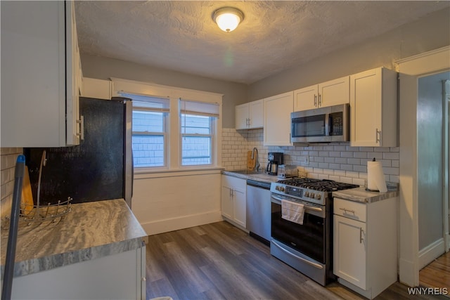 kitchen with dark wood-type flooring, white cabinetry, and stainless steel appliances