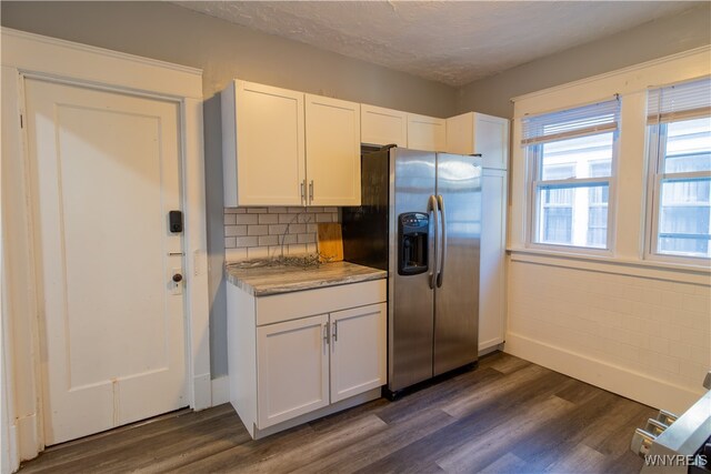 kitchen with stainless steel fridge, white cabinets, tasteful backsplash, dark hardwood / wood-style flooring, and a textured ceiling