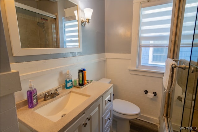 bathroom featuring an enclosed shower, toilet, tile walls, vanity, and hardwood / wood-style flooring