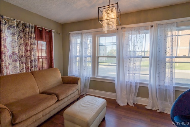 living room featuring an inviting chandelier, a textured ceiling, and dark hardwood / wood-style flooring