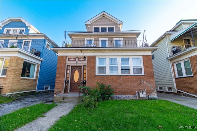 view of front of home with a front yard and a balcony