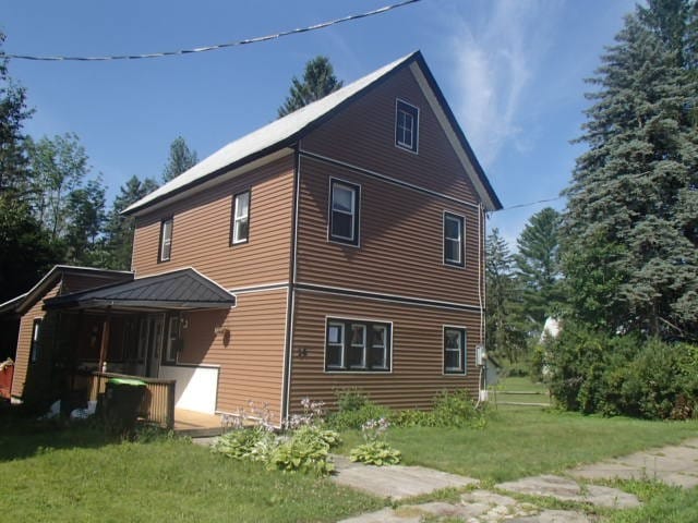 view of side of home with a yard