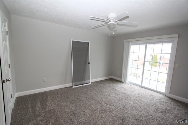 empty room featuring dark carpet and ceiling fan