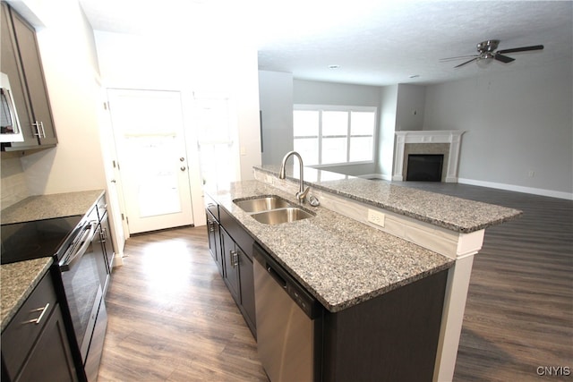 kitchen with appliances with stainless steel finishes, sink, an island with sink, and dark hardwood / wood-style flooring