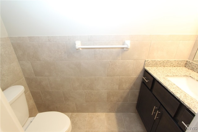 bathroom featuring vanity, tile walls, toilet, and tile patterned flooring