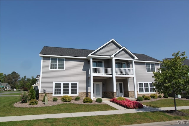 view of front of property with a balcony and a front lawn