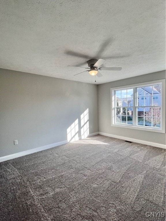 carpeted spare room with a textured ceiling and ceiling fan