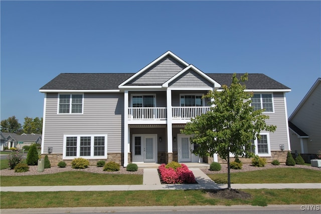 view of front facade with french doors, a front yard, and a balcony