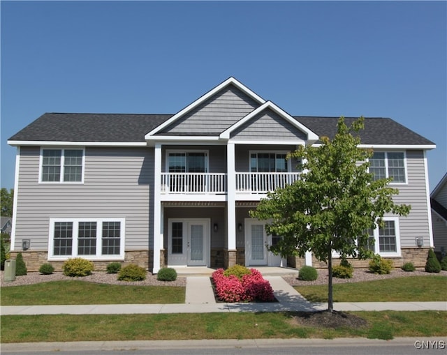 view of front of property featuring french doors, a front yard, and a balcony