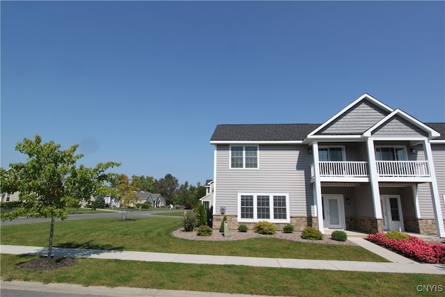 view of front facade with a balcony and a front lawn