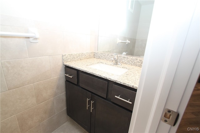 bathroom featuring vanity and tile walls