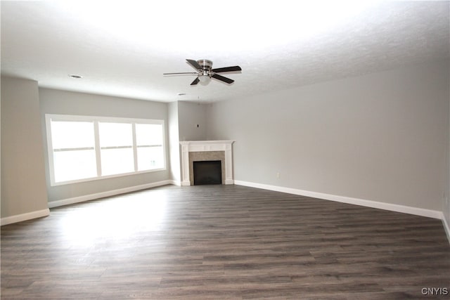 unfurnished living room with a textured ceiling, ceiling fan, and dark hardwood / wood-style flooring