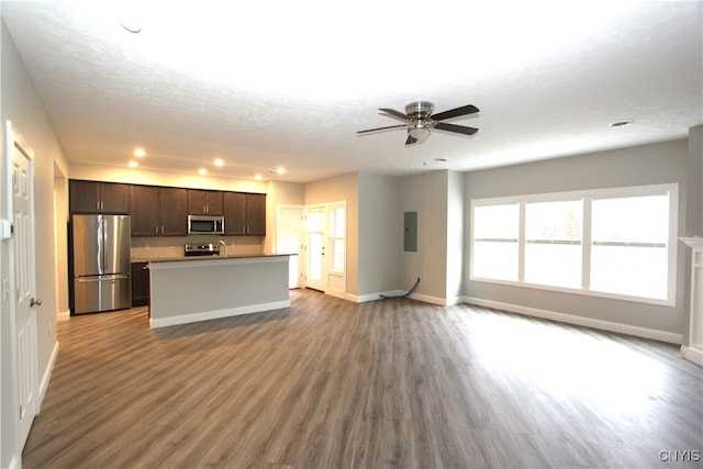 unfurnished living room featuring hardwood / wood-style floors, electric panel, a textured ceiling, and ceiling fan