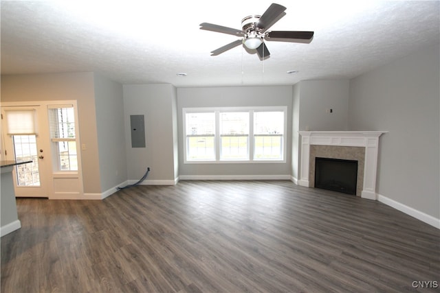 unfurnished living room featuring dark wood-type flooring, ceiling fan, a textured ceiling, and plenty of natural light